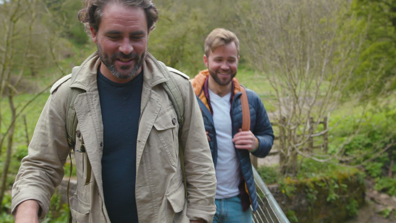 Levison Wood and Alex Bescoby walking together along a hillside path.