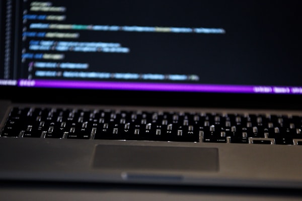 Software developer comparing platforms on laptop