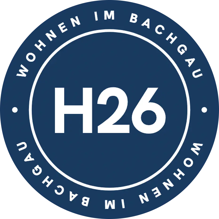 Logo Emblem Badge des Bauprojekts H26 Wohnen im Bachgau der May Firmengruppe. In der mitte steht "H26", im kreis darum die Worte "Wohnen im Bachgau"