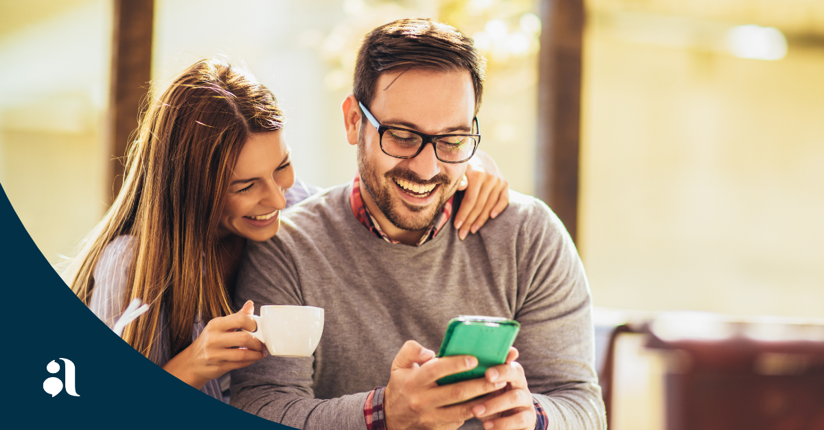 Two homebuyers excitedly viewing a community app inside a lifestyle-first welcome center in a master-planned community