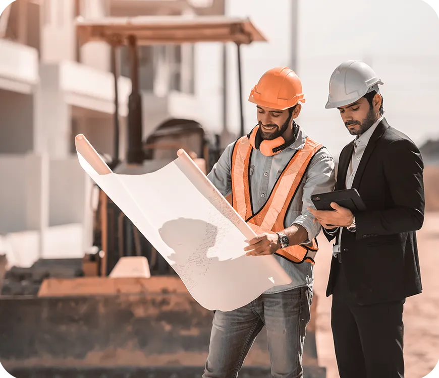 two workers holding construction map discussing 