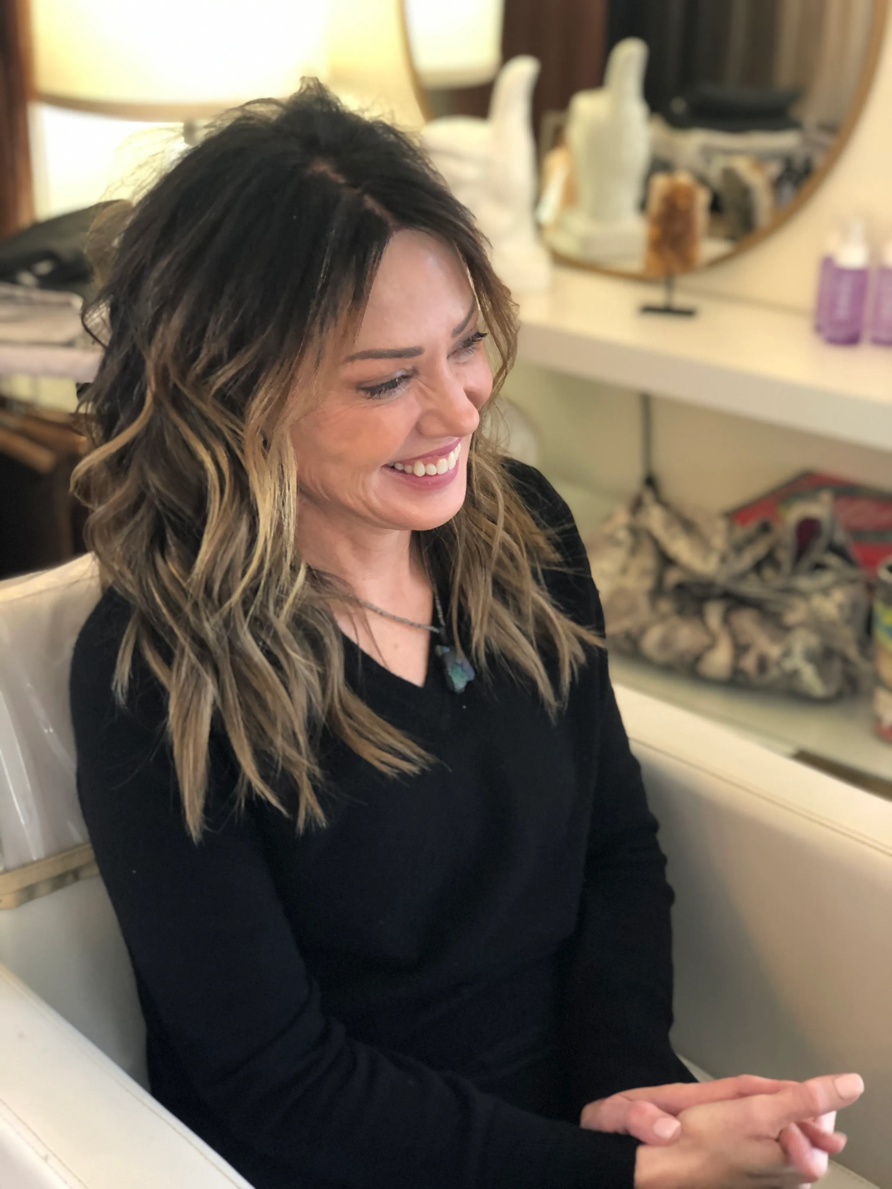 Client laughing in the salon with a textured shoulder-length balayage cut