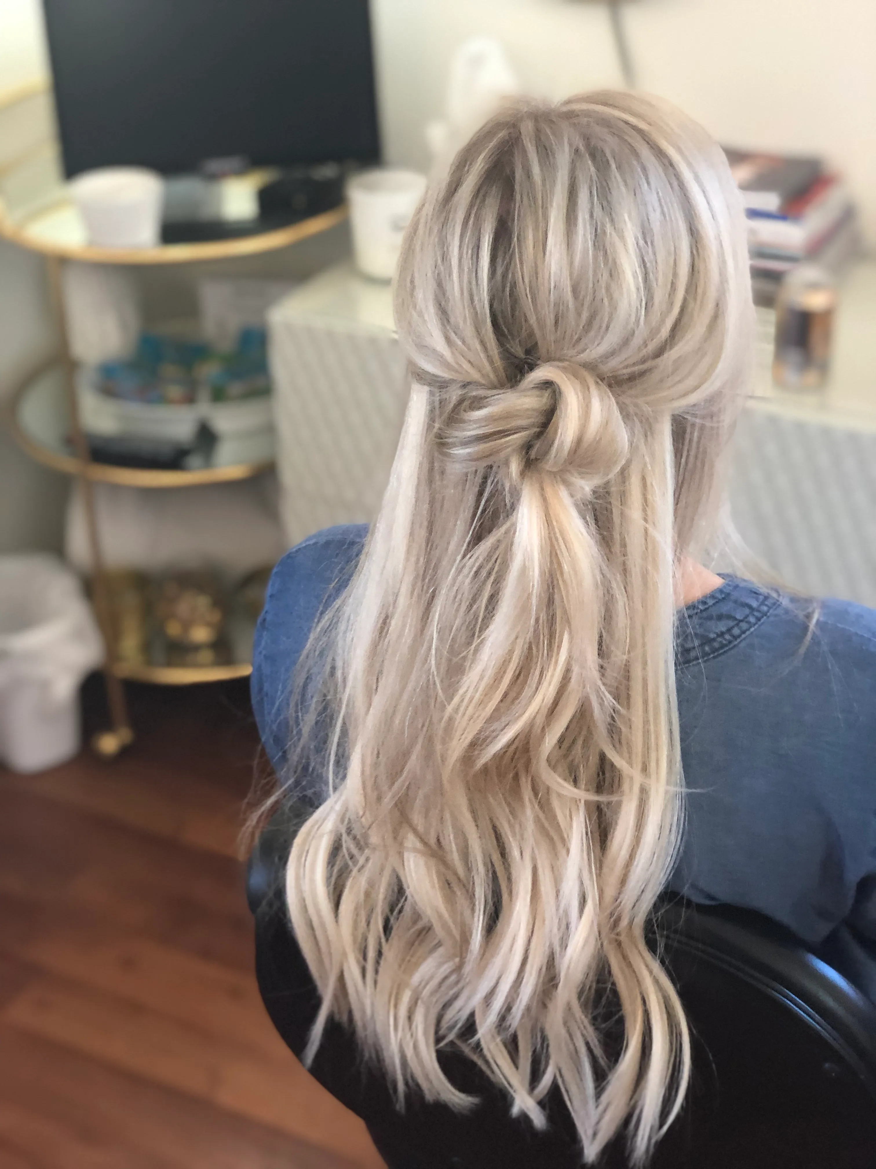 Half-up knot on long ash blonde hair with smooth lengths left down