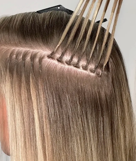Beaded row with strands of blonde hair pulled through, ready for wefts