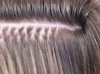 Close-up of a beaded row stitched along the part in ash blonde hair