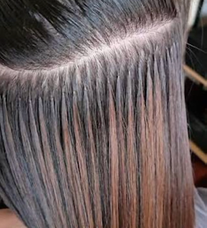 Individual keratin bonds lined up close to the scalp in dark brown hair