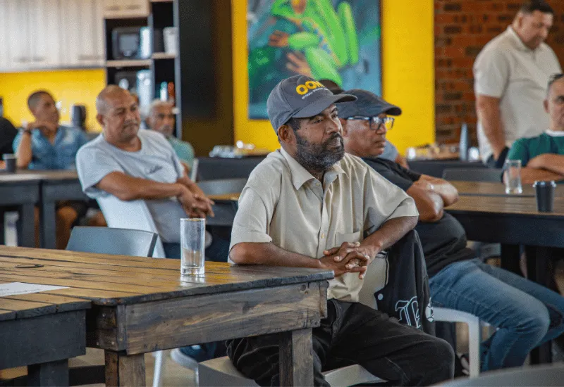 Men listening to the speaker sharing.