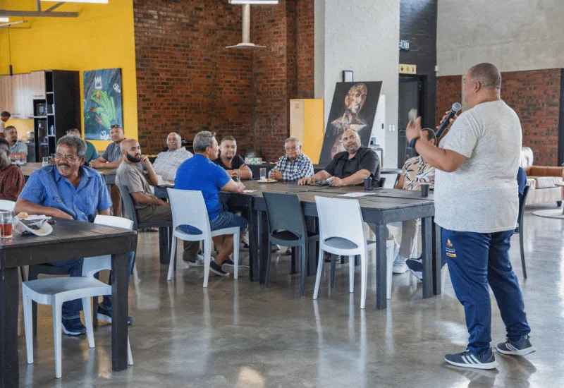 Men listening to another man sharing at the men's gathering.