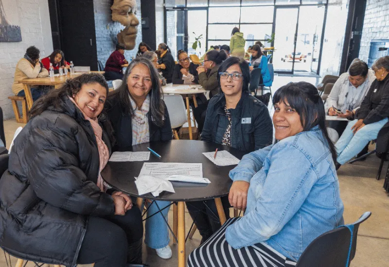 Women sitting around a table chatting.