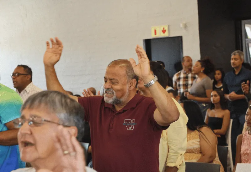 Man worshiping with his arms raised in the air.