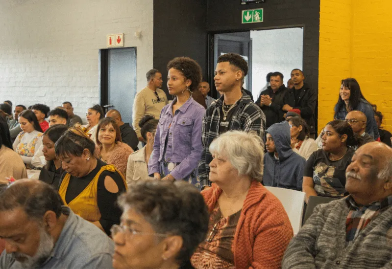 Two new teen members standing while they are being welcome.