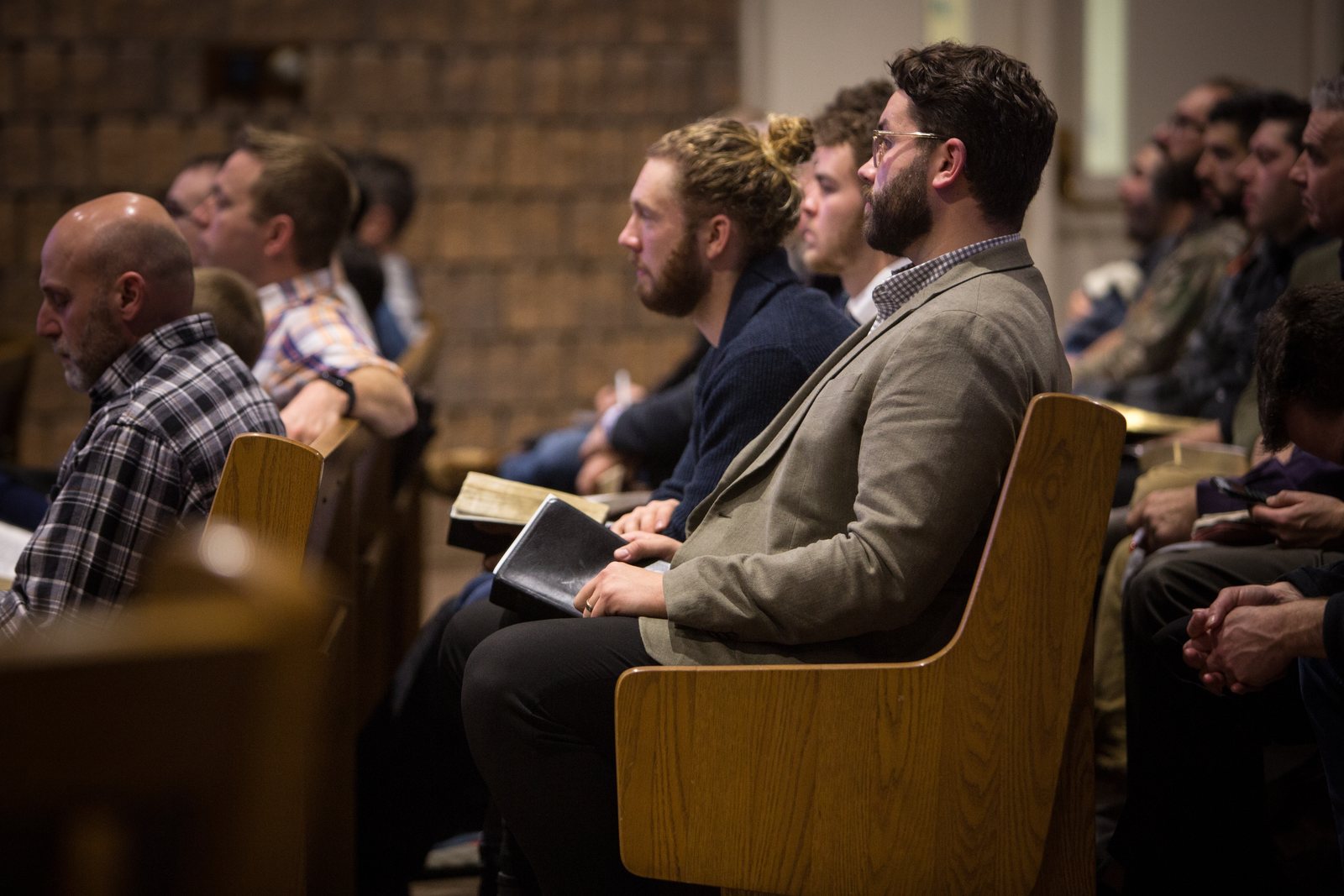 Young men following along in their Bibles