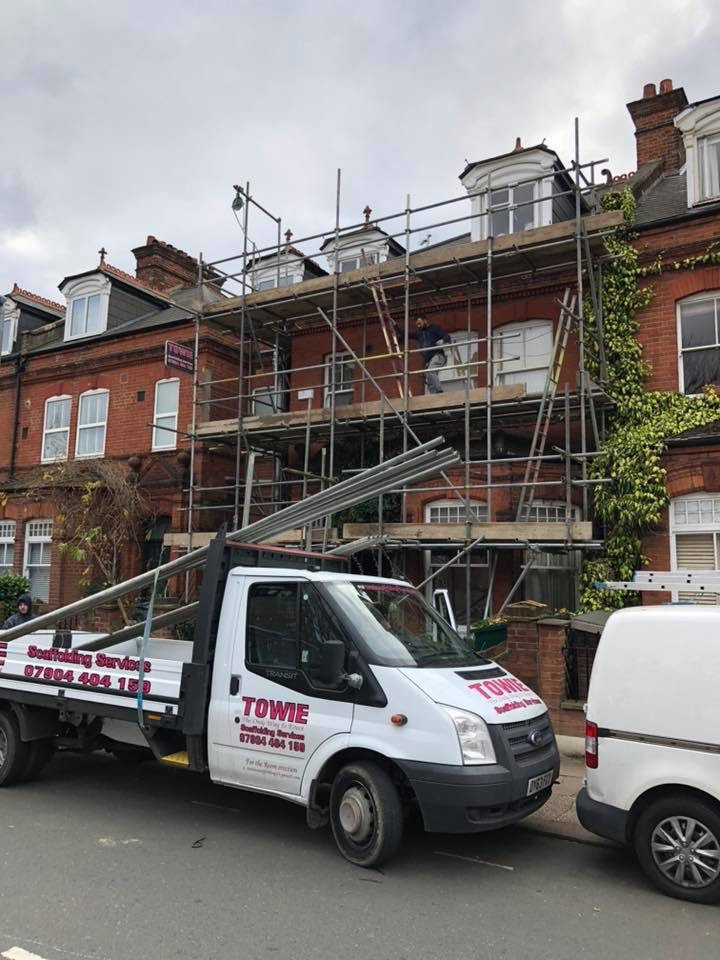 scaffolding on house with white van
