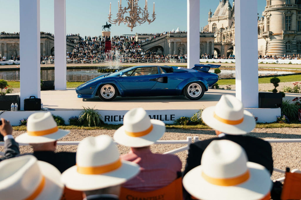 Classic car displayed at a concours d'elegance with spectators watching.