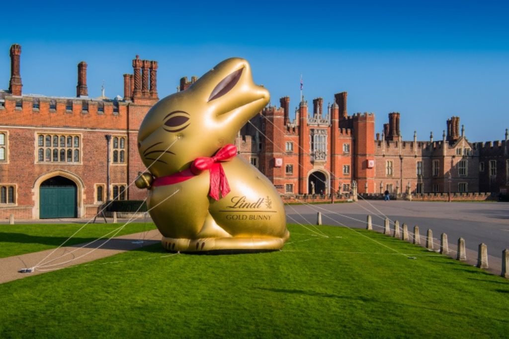 Historic estate lawn decorated for Easter weekend with large golden bunny sculpture and spring atmosphere.