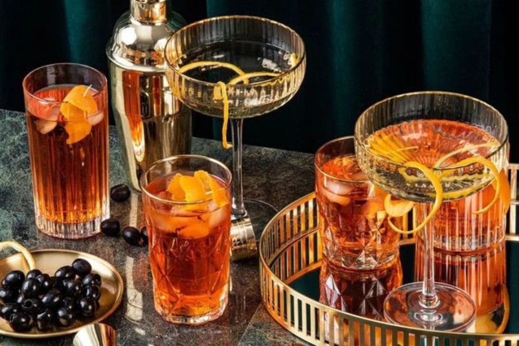 Elegant cocktail drinks served in crystal glasses on a bar table during a stylish evening cocktail party.