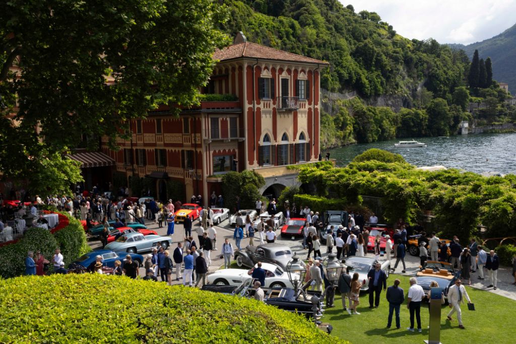 Guests attending Concorso d’Eleganza Villa d’Este beside classic cars on Lake Como.