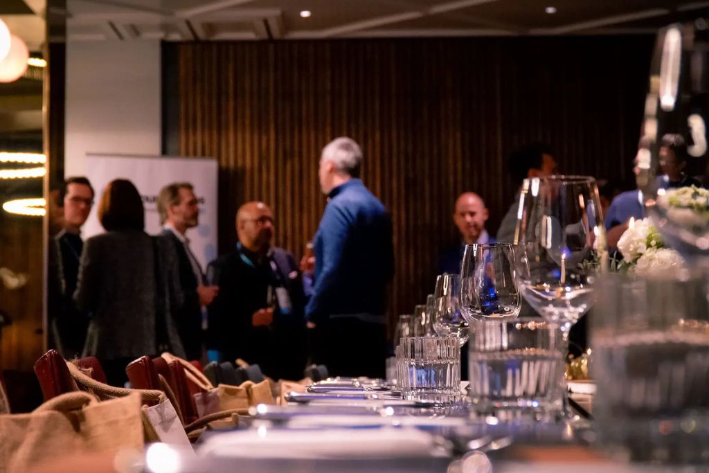 Professionals attending a corporate seminar in a modern business hospitality setting.