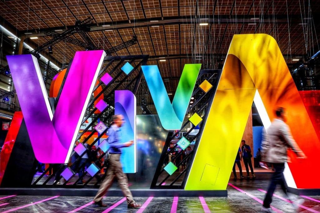 Attendees walking through the colourful VivaTech exhibition space during the annual technology conference in Paris.