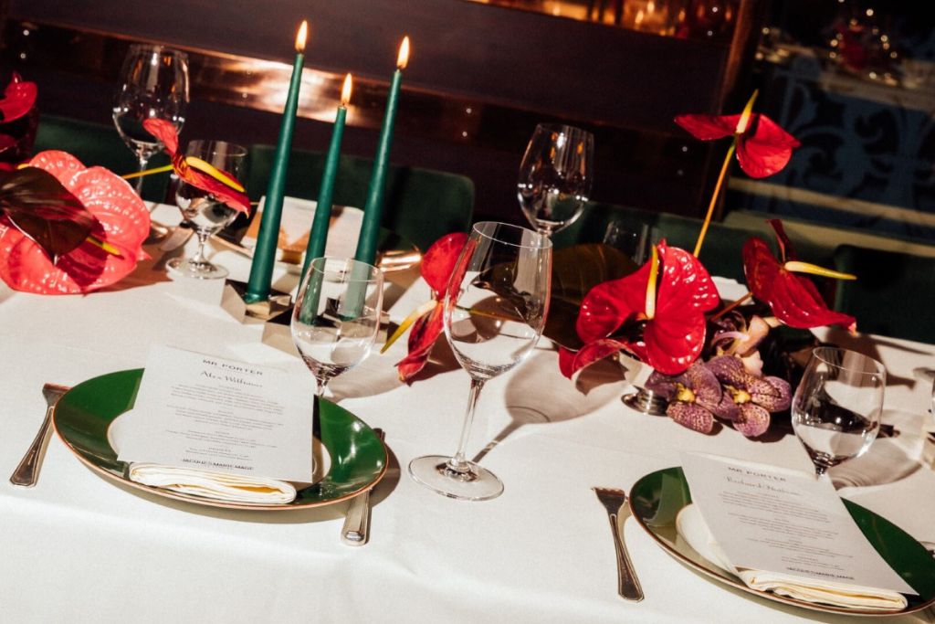 Elegant candlelit restaurant setting for a dinner date, with wine glasses, flowers and a refined romantic atmosphere.