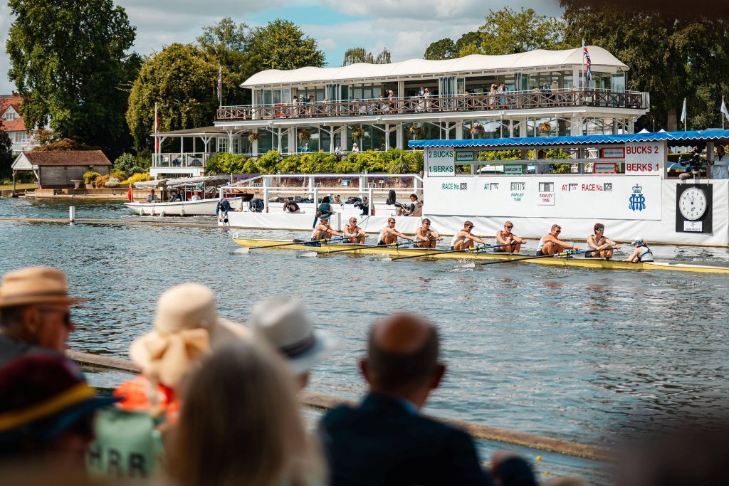 Spectators watching rowing races during the Henley Royal Regatta beside the River Thames in the Stewards' Enclosure.