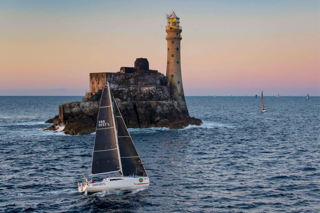 Sailboat competing in the Rolex Fastnet Race near Fastnet Lighthouse on the coast of Ireland.