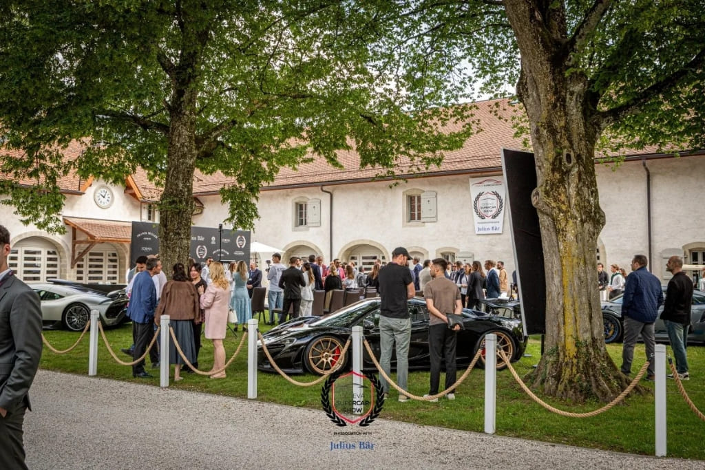 Guests viewing supercars on display at the Geneva Supercar Show, set in the grounds of a historic estate.