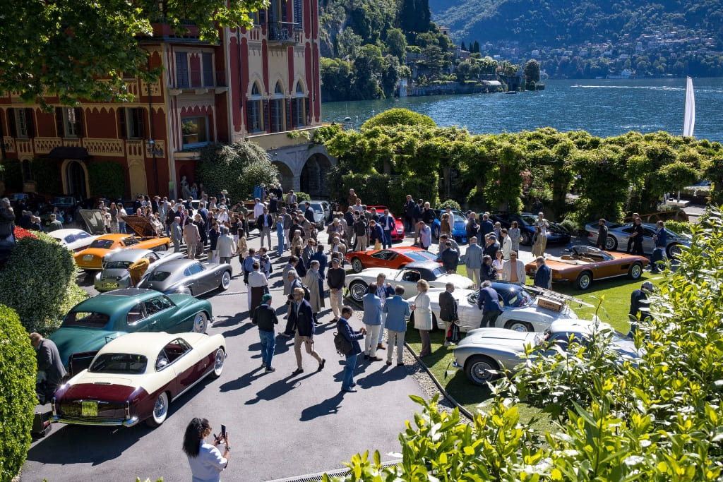 Classic cars displayed at the Concorso d’Eleganza Villa d’Este beside Lake Como, with guests gathered around the historic venue.