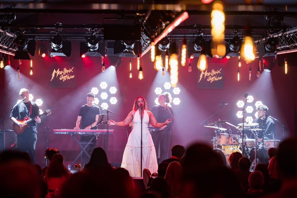 Live jazz band performing on stage inside an intimate jazz club with guests enjoying the evening.