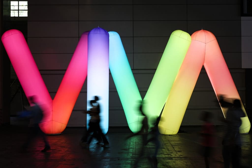 Visitors walking past the colorful VivaTech installation at the Viva Technology event in Paris.