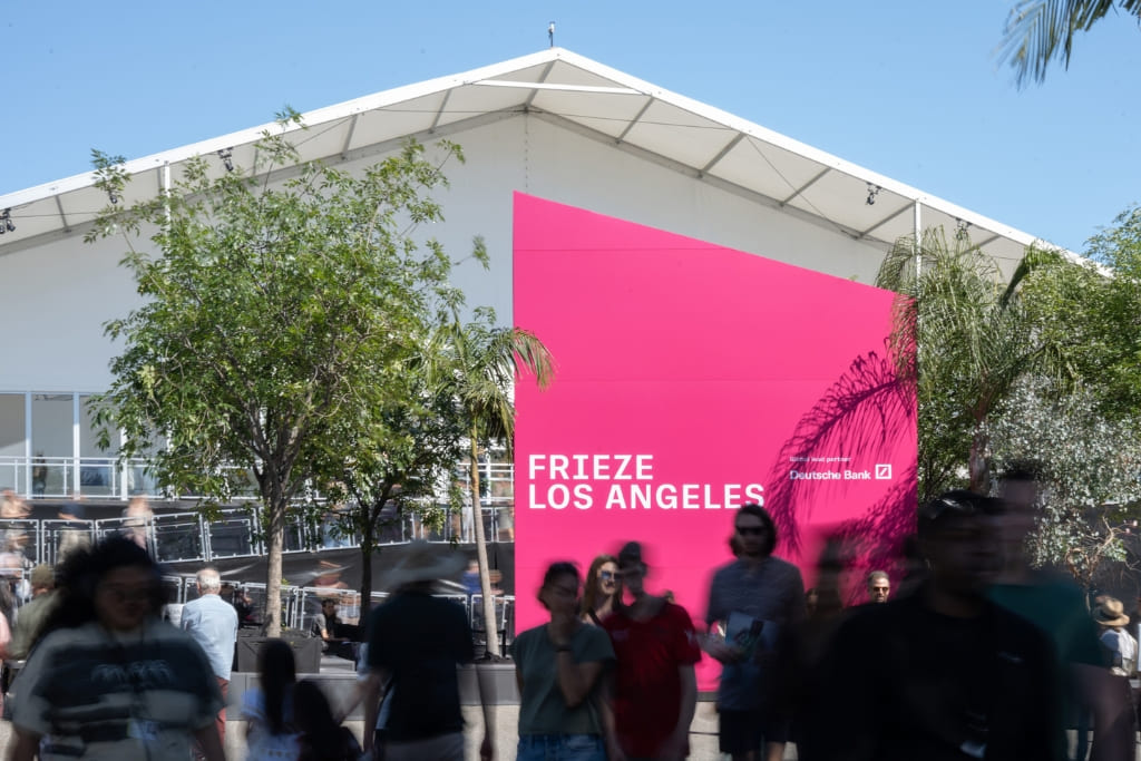 Visitors arriving at Frieze Los Angeles, with the fair’s entrance signage and exhibition tent in the background.
