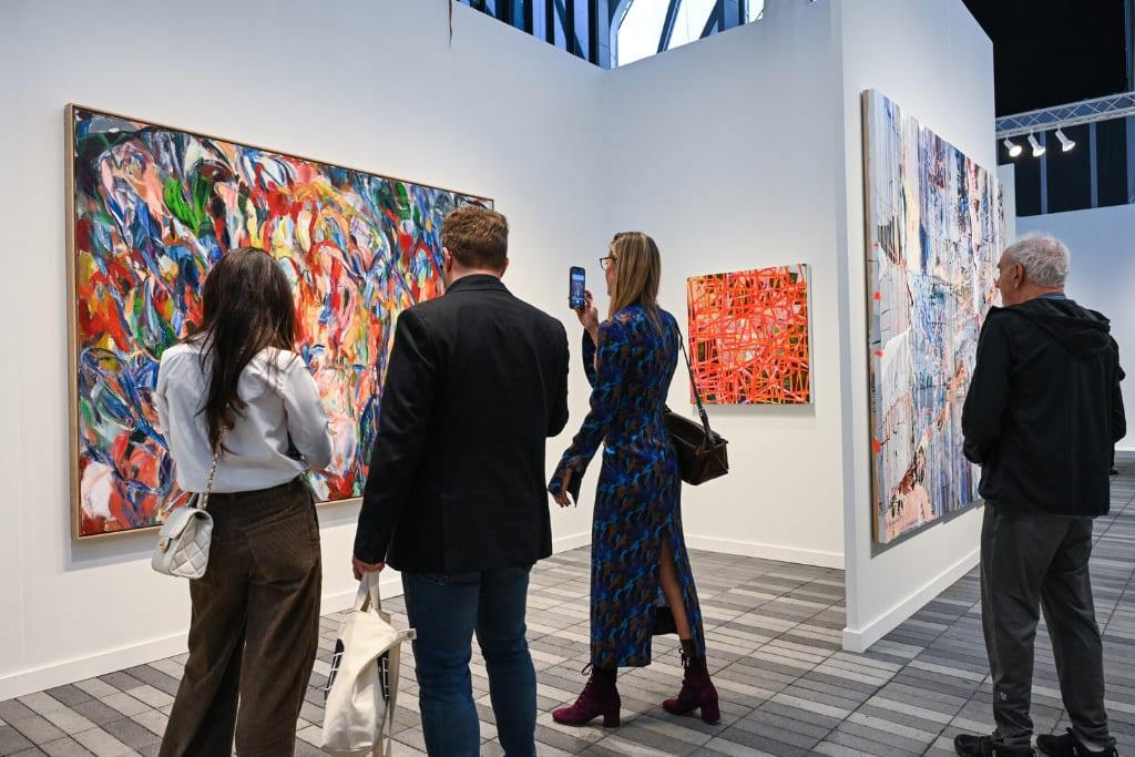 Visitors viewing contemporary artworks at a modern art gallery exhibition.