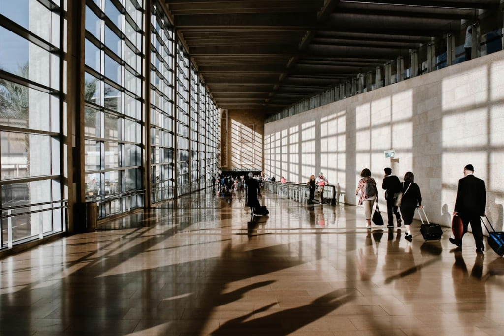 Travelers walking through a modern airport terminal during a business trip.