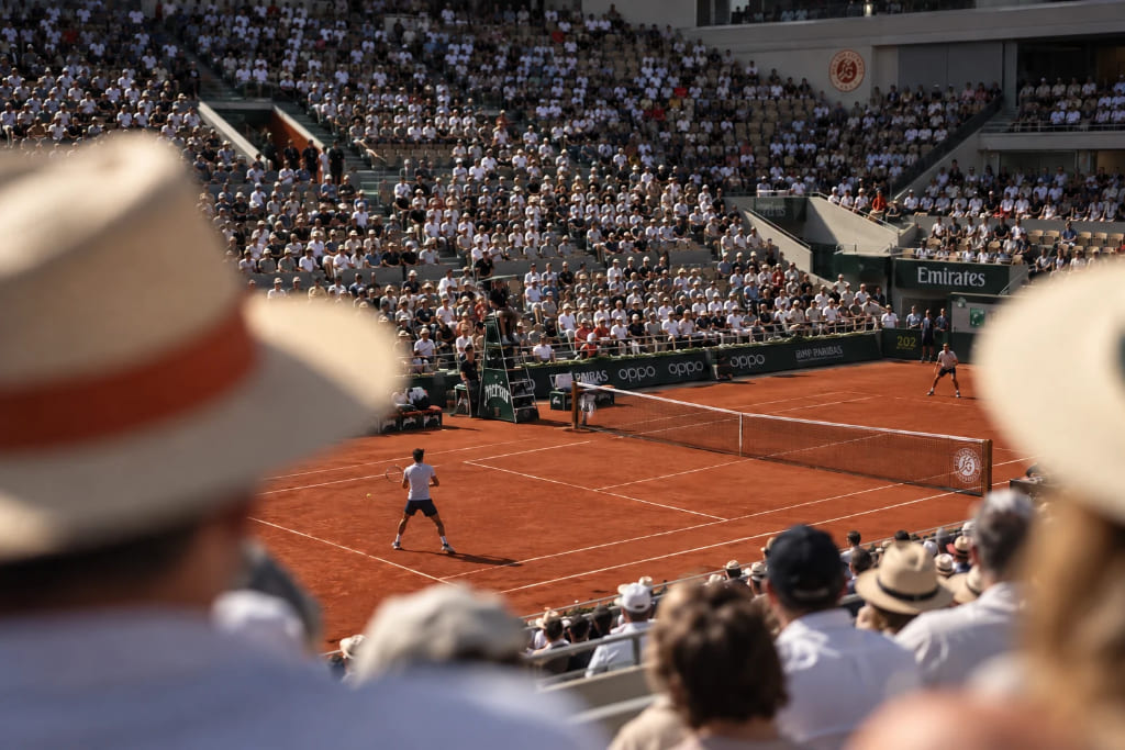 Spectators attending Roland-Garros tennis tournament during a summer afternoon in Paris.