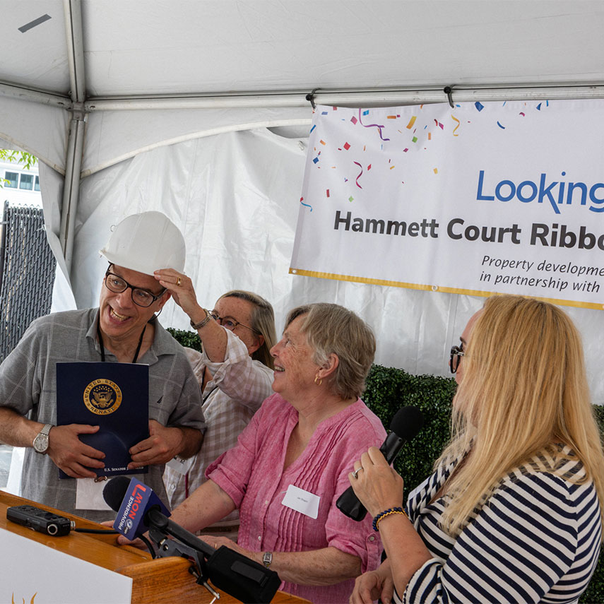 Ribbon cutting scissors being handed to Denise Lussier from Looking Upwards