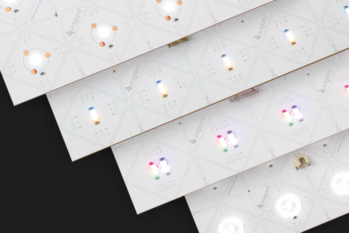 Four light sheets with various LED lights and electronic components arranged diagonally on a black background.