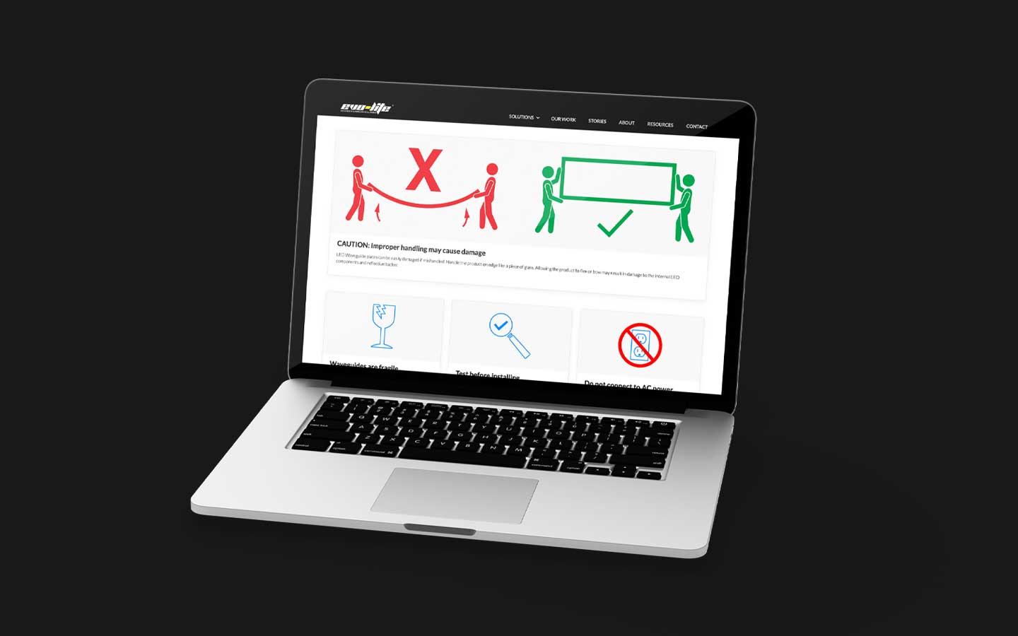 Laptop displaying a webpage with handling instructions showing a red X for improper lifting and a green checkmark for correct lifting.