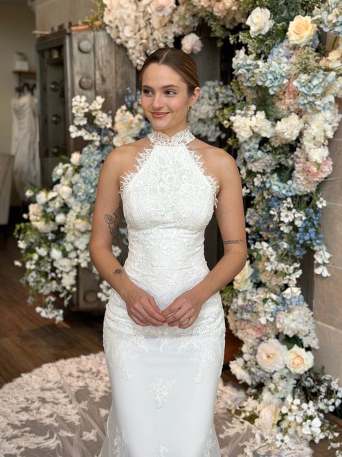 Bride wearing a fitted high neckline wedding dress with sheer illusion details in Virginia bridal shop