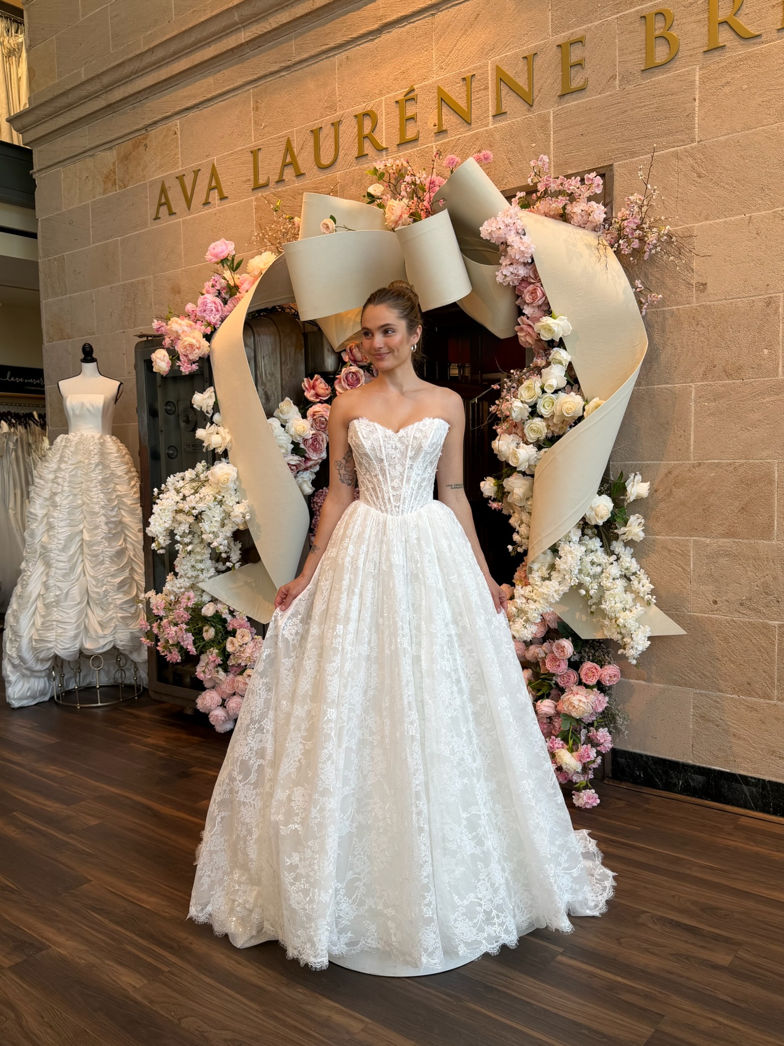 Bride modeling a strapless floral A line wedding gown during wedding dress shopping in Fredericksburg Virginia.