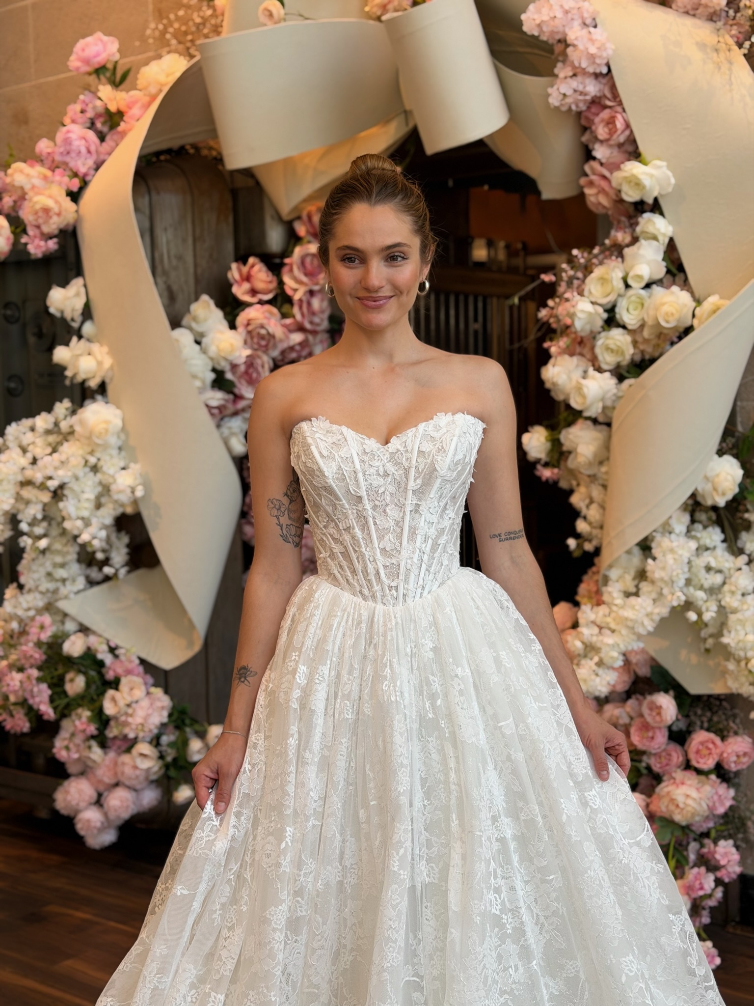 Bride modeling a strapless floral A line wedding gown during wedding dress shopping in Fredericksburg Virginia.