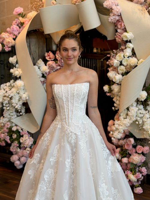 Bride modeling a strapless floral A line wedding gown during wedding dress shopping in Fredericksburg Virginia.