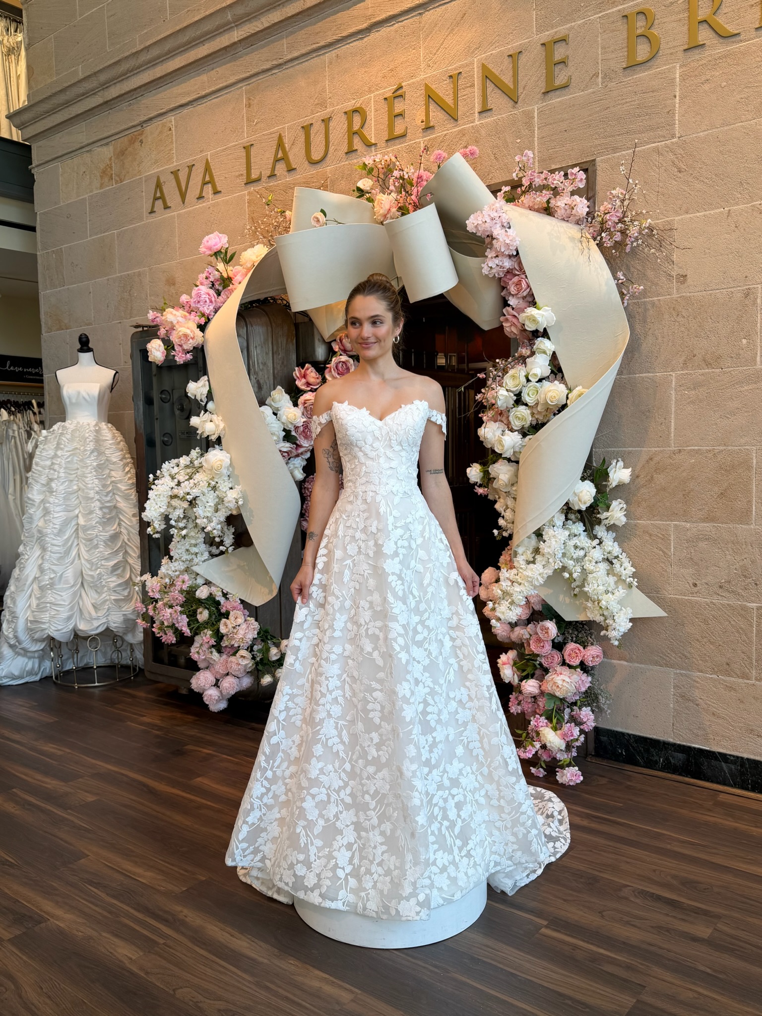 Bride modeling a strapless floral A line wedding gown during wedding dress shopping in Fredericksburg Virginia.