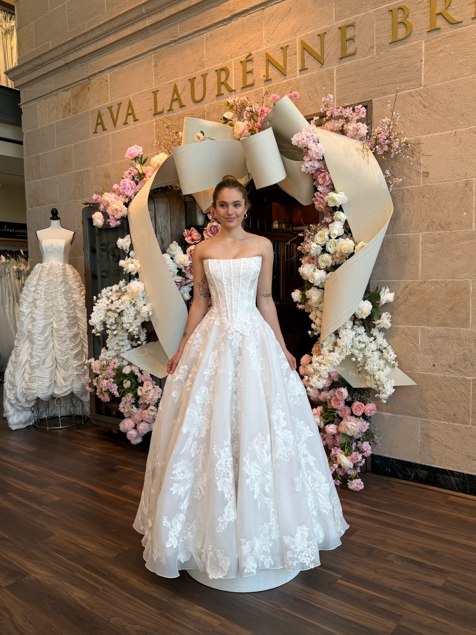 Bride modeling a strapless floral A line wedding gown during wedding dress shopping in Fredericksburg Virginia.