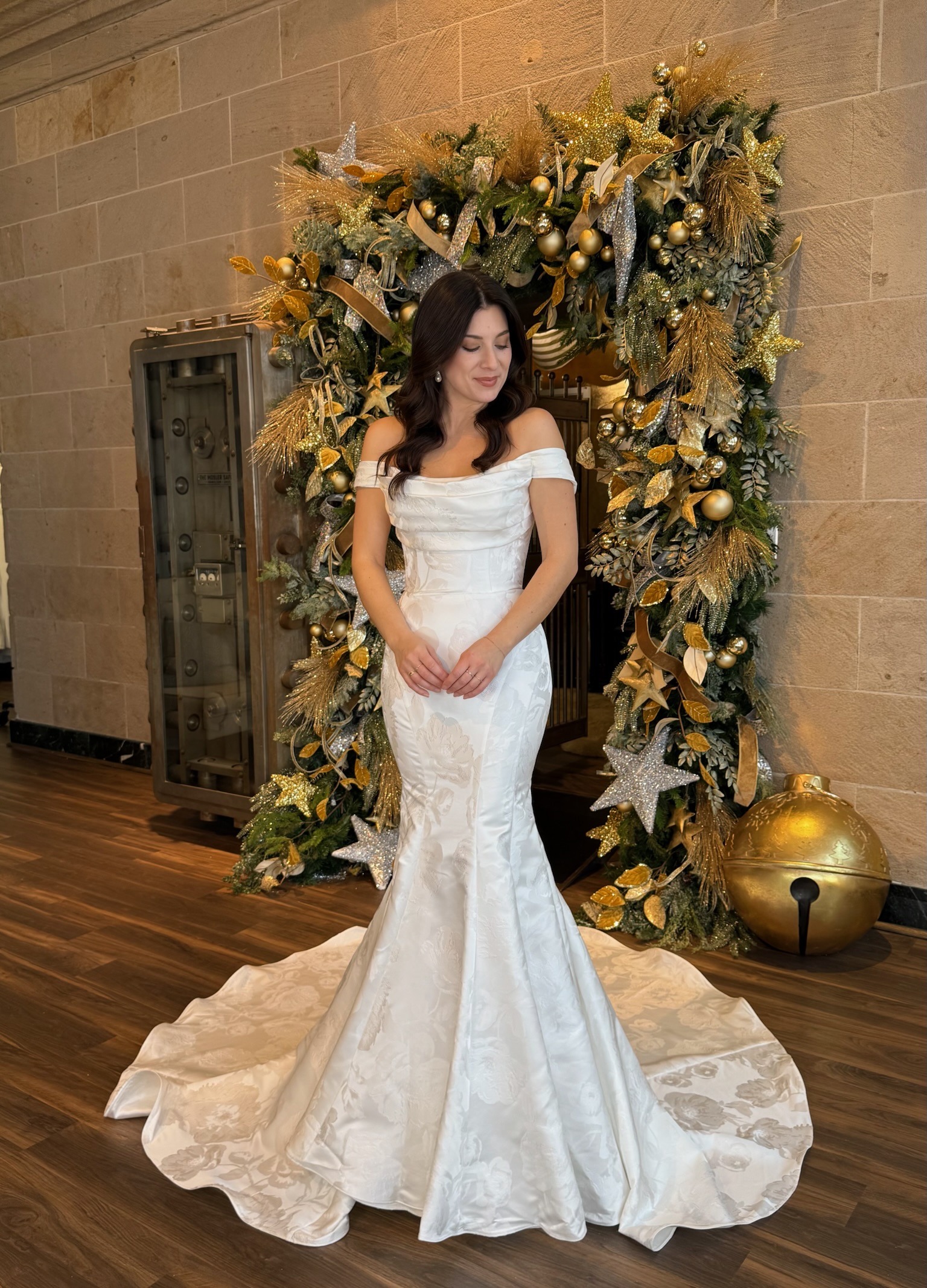 Bride showcasing the back of an off the shoulder lace wedding dress with detailed button closure