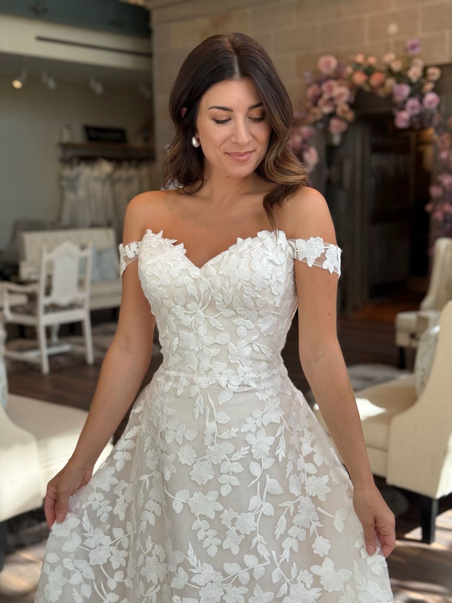 Luxury bridal fashion featuring an off the shoulder neckline and full skirt wedding gown