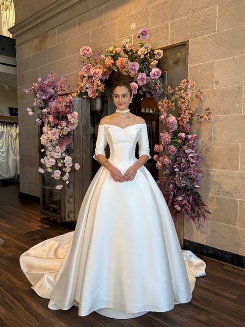 Statement off the shoulder wedding gown with dramatic volume and luxurious lace embellishments