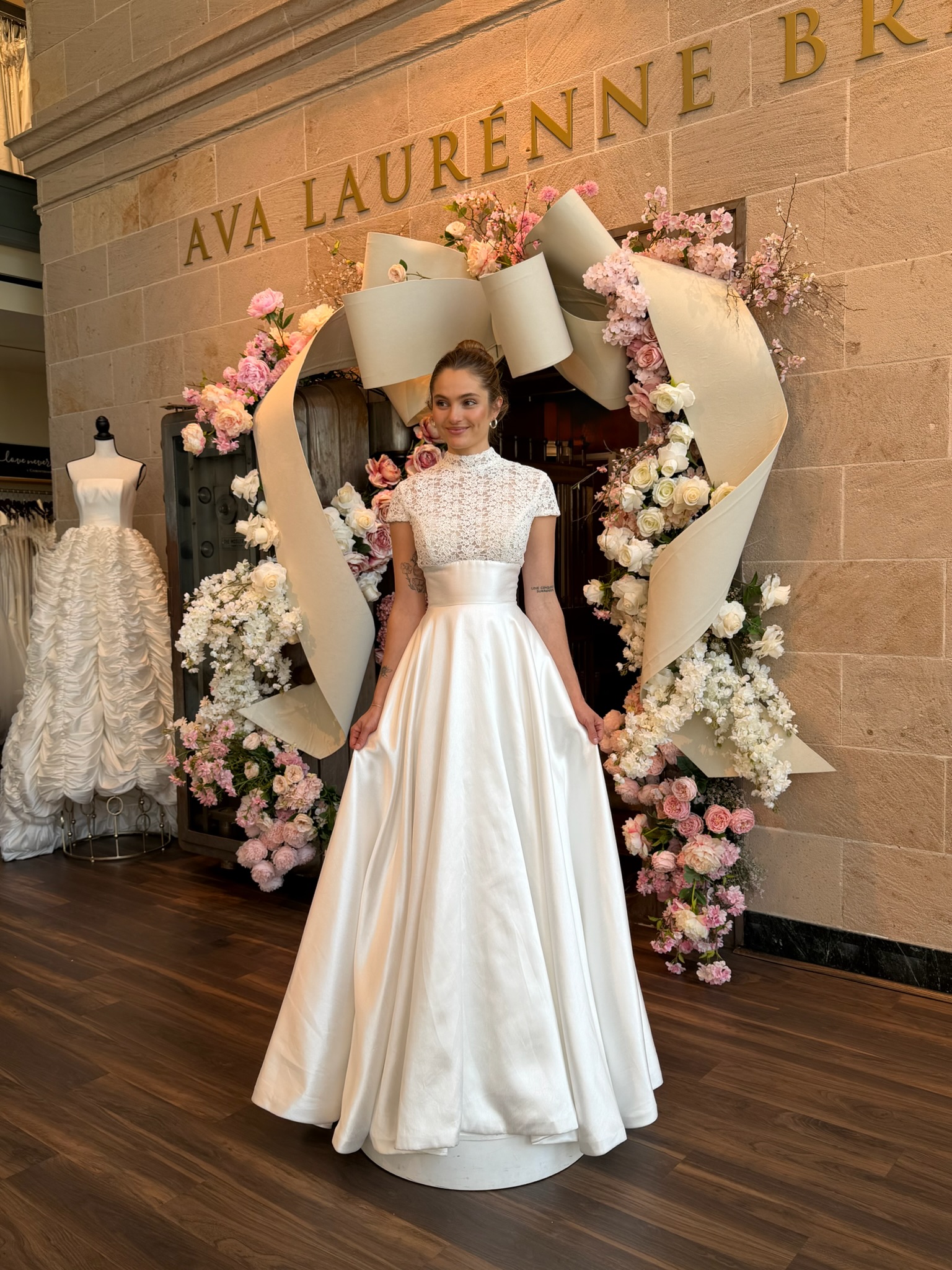Bride wearing a fitted high neckline wedding dress with sheer illusion details in Virginia bridal shop