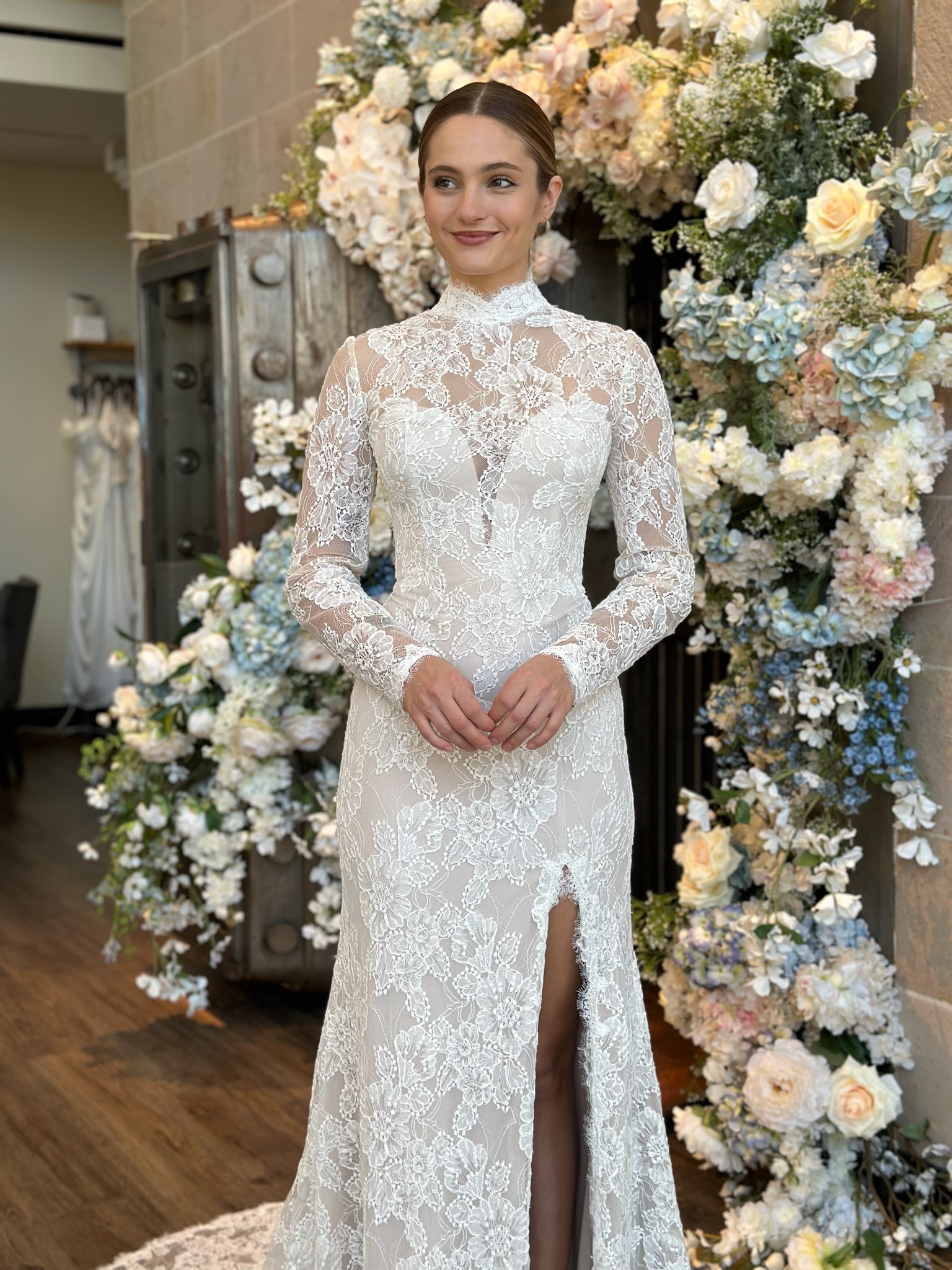 Bride wearing a fitted high neckline wedding dress with sheer illusion details in Virginia bridal shop