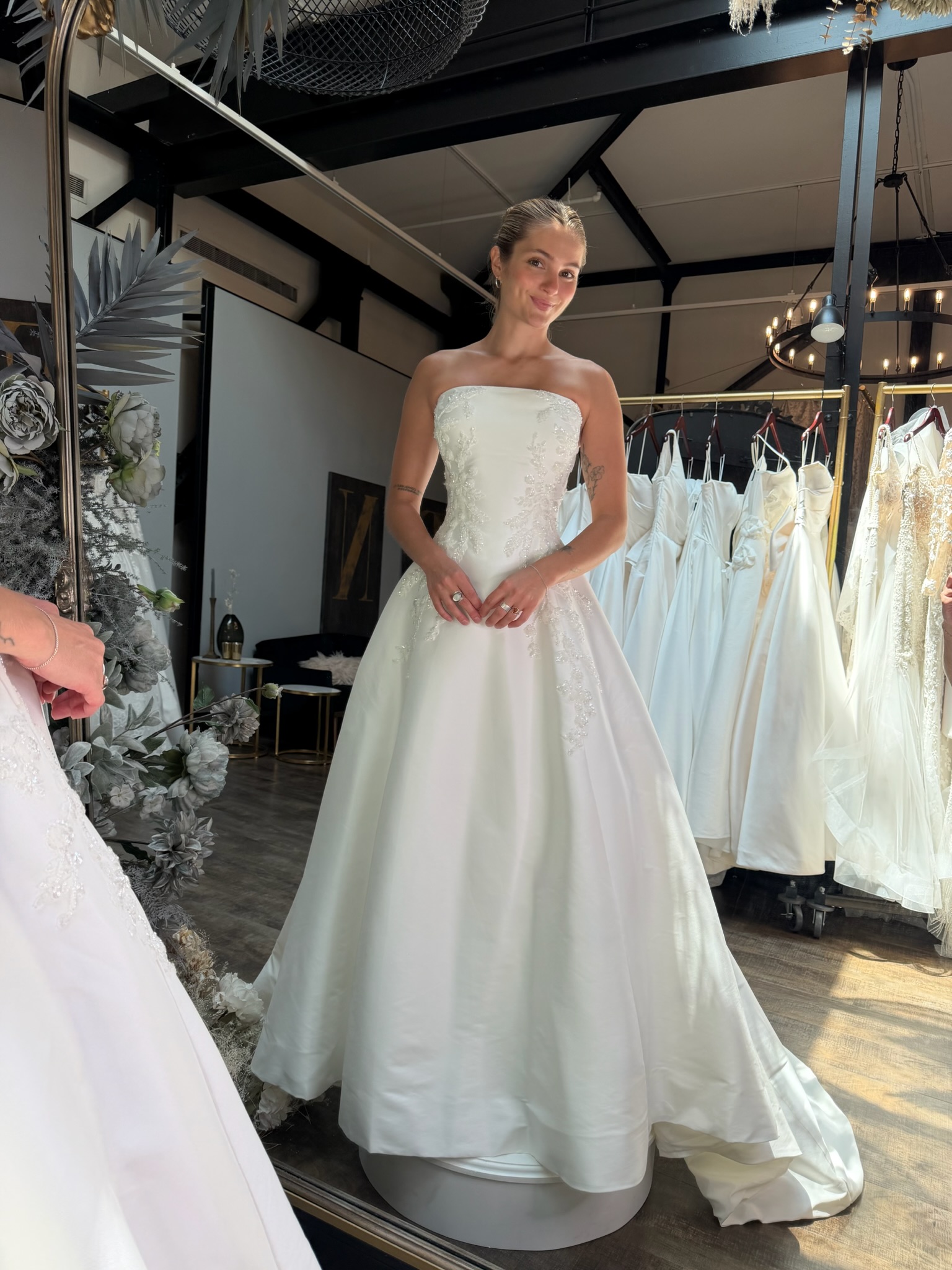 Modern strapless wedding dress with a draped bodice and dramatic satin skirt