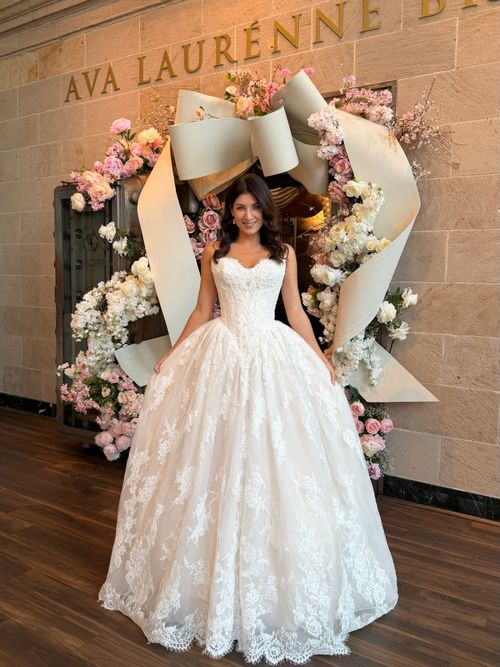 Bride trying on a romantic strapless lace wedding dress at Ava Laurènne Bride in Fredericksburg, Virginia